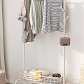 Standing Clothes Rack with Hanging Shirts Striped Tops and Storage Basket Near Curtain and Woven Stool