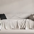 White Large Sofa With Black And Light Pillows On Wrinkled Fabric Near Stack Of Books