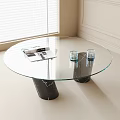 Round Glass Coffee Table With Black Marble Bases And Magazine Glass Cups In Modern Interior