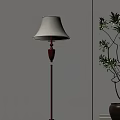 Red Pole Floor Lamp With Beige Lampshade Illuminating White Wall And Green Plant