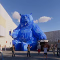 Vibrant Commercial Street Featuring Giant Blue Bear Sculpture and Pedestrians Near Modern Buildings