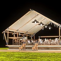 Outdoor White Tent With Wooden Structure Tables Chairs Decorative Lights On Green Grass