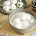 Fresh White Meatballs in Bowl with Water on Plate with Green Leaves Salt on Table