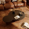 Elegant Brown Leather Sofa With Black Round Coffee Table And Side Table On Wooden Parquet Floor