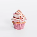 Delicious Pink Cupcake With Swirled Frosting Red Sprinkles And Striped Paper Liner On White Background