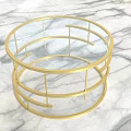 Elegant Round Coffee Table With Gold Metal Frame And Glass Top On Marble Surface