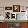 Gallery Wall With Various Framed Artworks Different Styles Wooden Cabinet And Books On Top