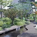 Serene Garden Landscape Design With Winding Pathway Flowing Stream And Lush Greenery