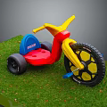 Kids Tricycle with Yellow Handlebars Red Body Blue Seat Black Wheels on Green Grass