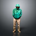 A Man Standing In Green Hooded Jacket Khaki Pants With Hands In Pockets Gray Background
