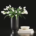 White Tulips in Black Vase with Green Leaves and White Bowl on Stacked Books