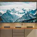 TV Displaying Snowy Mountain Scene Mounted on Wooden Wall with Cabinet Speakers and Green Plant