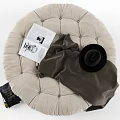 Stacked Poufs In Various Colors With Blanket Books And Hat Nearby
