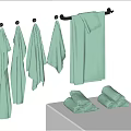 Light Green Towels Hanging On Hooks And Folded On White Countertop