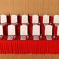 Red Tablecloth Conference Table With White Chairs Notebooks And Water Bottles 3d model