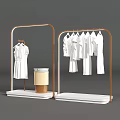 Art Installation Featuring Golden Frame Clothing Racks With White Garments And Lamp Display Stand