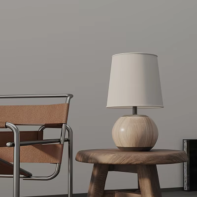 Wooden Base Table Lamp With Beige Shade On Wooden Side Table Next To Leather Chair 3d model