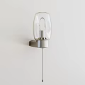 Modern Wall Light With Transparent Glass Shade And Silver Metal Base Mounted On White Wall