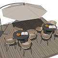 Outdoor Table with Wicker Chairs and Patio Umbrella on Wooden Deck with Fruit and Book