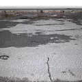 Damaged Asphalt Pavement With Visible Cracks And Potholes On Surface