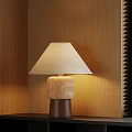 Beige Lampshade Table Lamp With Layered Base And Wooden Wall Background