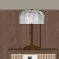 Bedside Table With Rattan Detail And Wooden Table Lamp With Beige Lampshade On Wooden Wall