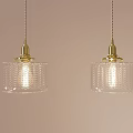 Two Golden Pendant Lights With Textured Transparent Glass Shades Illuminated On Light Pink Wall