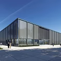 Large Modern Industrial Factory Building Featuring Metal Facade Glass Windows And Doors With People Walking