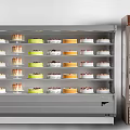 Refrigerated Display Freezer With Multiple Shelves Holding Various Cakes In Bakery