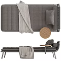 Comfortable Gray Ottoman With Woven Backrest Cushions Wooden Small Round Table And Draped Blanket