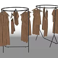 Round Clothes Rack With Black Metal Frame Holding Brown Dresses And Tops