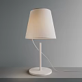 White Table Lamp With Fabric Shade Slim Pole And Round Base On Gray Wall Background
