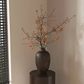 Ceramic Vase With Orange Flower Branches On Small Black Table Against Light Wall Near Window With Blinds And Green Plants Outside