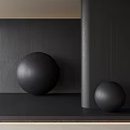Black Sphere Sculptures Against Dark Wood Grain Wall With Gray Cylindrical Column On Dark Floor