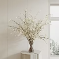 White Blossom Branches in Glass Vase on Table by Window With Snowy View