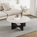 Modern Round Coffee Table With Black Base And Decorative Plant In Living Room Interior