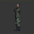Military Soldier In Camouflage Uniform With Green Cap Standing Arms Crossed On Gray Background