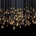 Cluster of Small Golden Chandeliers Hanging With Black Wires Against Dark Background