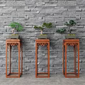 Bonsai Plants Displayed On Red Wooden Plant Stands Against Gray Brick Wall