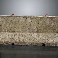 Roadside Weathered Concrete Barrier With Red Rings And Bottom Holes