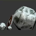 Decorative Grey Stone Object With Round Shield Featuring Red And Yellow Pattern And Small Stones