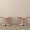 Two T Shaped Pink And Beige Stools Against Light Wall On Light Floor
