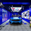Blue Sports Car Showroom With Posters On Walls And Checkerboard Floor Pattern