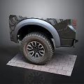Black Pickup Truck Rear View With Large Off-Road Tires Silver Fender Flares On Brick Pavement