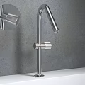 Sleek Modern Stainless Steel Faucets With Different Heights On White Countertop Grey Wall