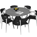 Modern Round Dining Table with Six Black Chairs Fruit Bowl and Open Book