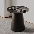 Round Black Wooden Coffee Table With Conical Base And Magazine Pinecones On Rug