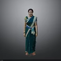 Woman In Green Saree With Blue Yellow Accents And Bangles Against Grey Background