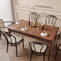 Modern Wooden Dining Table Set with Black Woven Back Chairs Vase White Flowers Coffee Cups