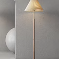 Pleated Shade Wooden Floor Lamp Against Concrete Wall With White Sphere